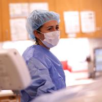 A medical professional wearing scrubs in a hospital.